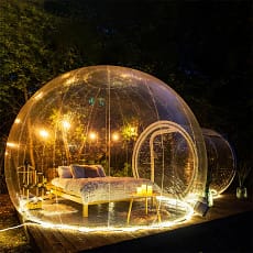 Tente bulle transparente photo de nuit, intérieur avec éclairage jaune.